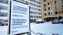 Kyltti, joka ohjaa koronarokotukseen Hatanpään rokotuspisteeseen. Taustalla kerrostalo. Lunta maassa.
