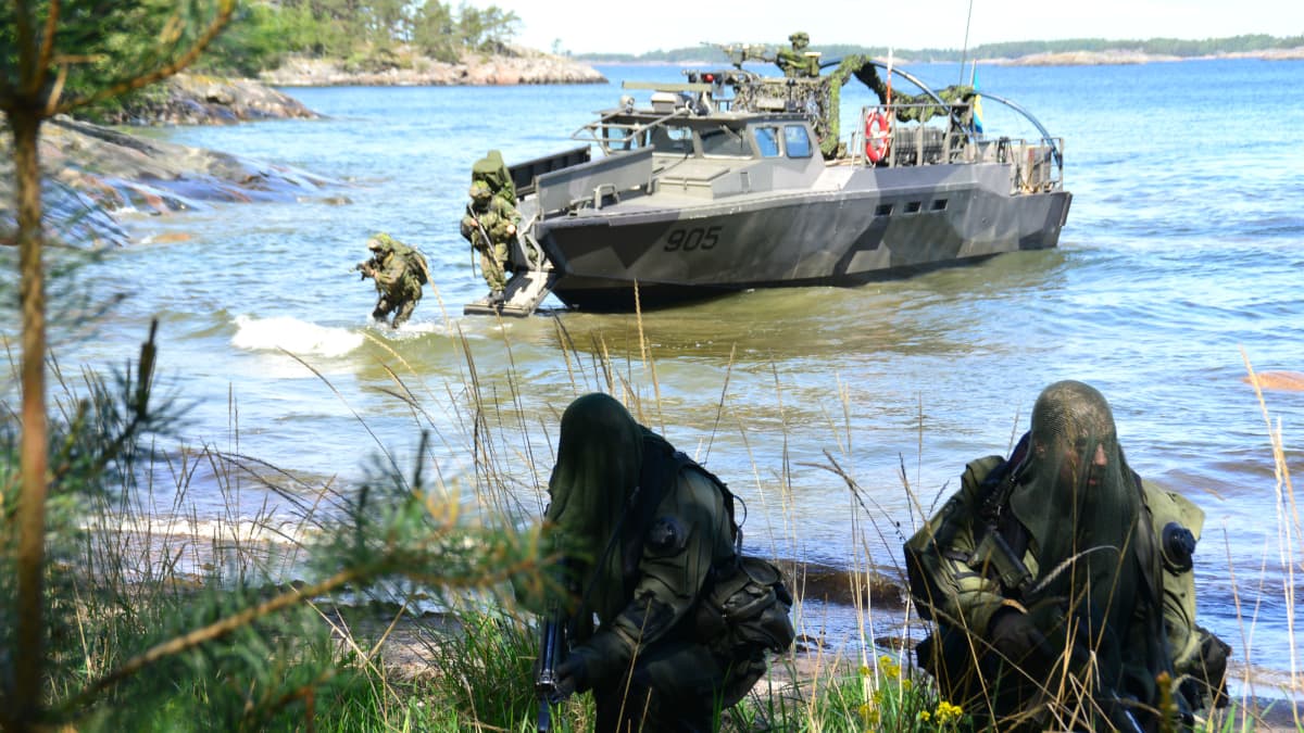 militär personal under övning vid strand