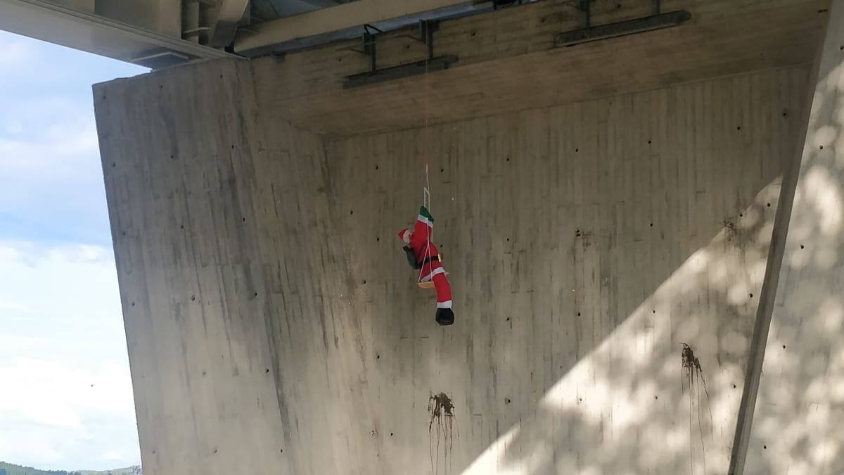 Joulupukkihahmo Kuokkalan sillan alla keinumassa.