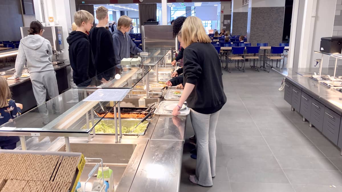 Oppilaita ruokalinjastolla koulun ruokalassa.