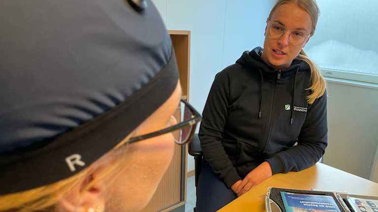 Kaksi hoitajaa keskustelee pöydän äärellä.