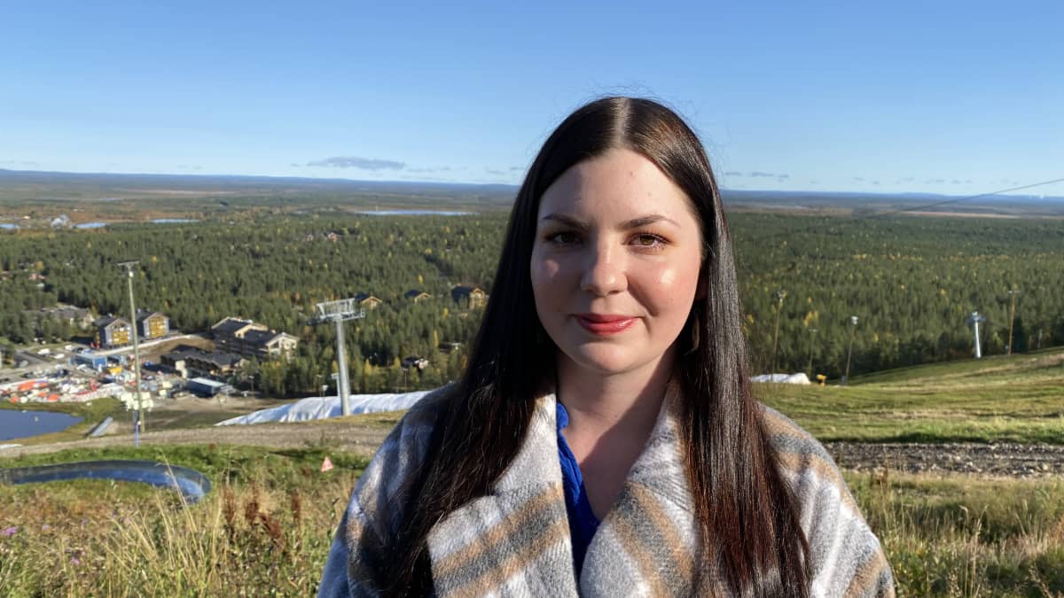 Lapin Yrittäjien toimitusjohtaja Ella-Noora Kauppinen katsoo kameraan Levin rinteessä alkusyksyllä, kun ruoho on jo kellastunut ja taivas on sininen.