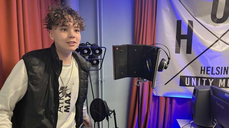 15-vuotias Romeo Ouni mikrofonin luona Herttoniemen nuorisotalon musiikkistudiossa.