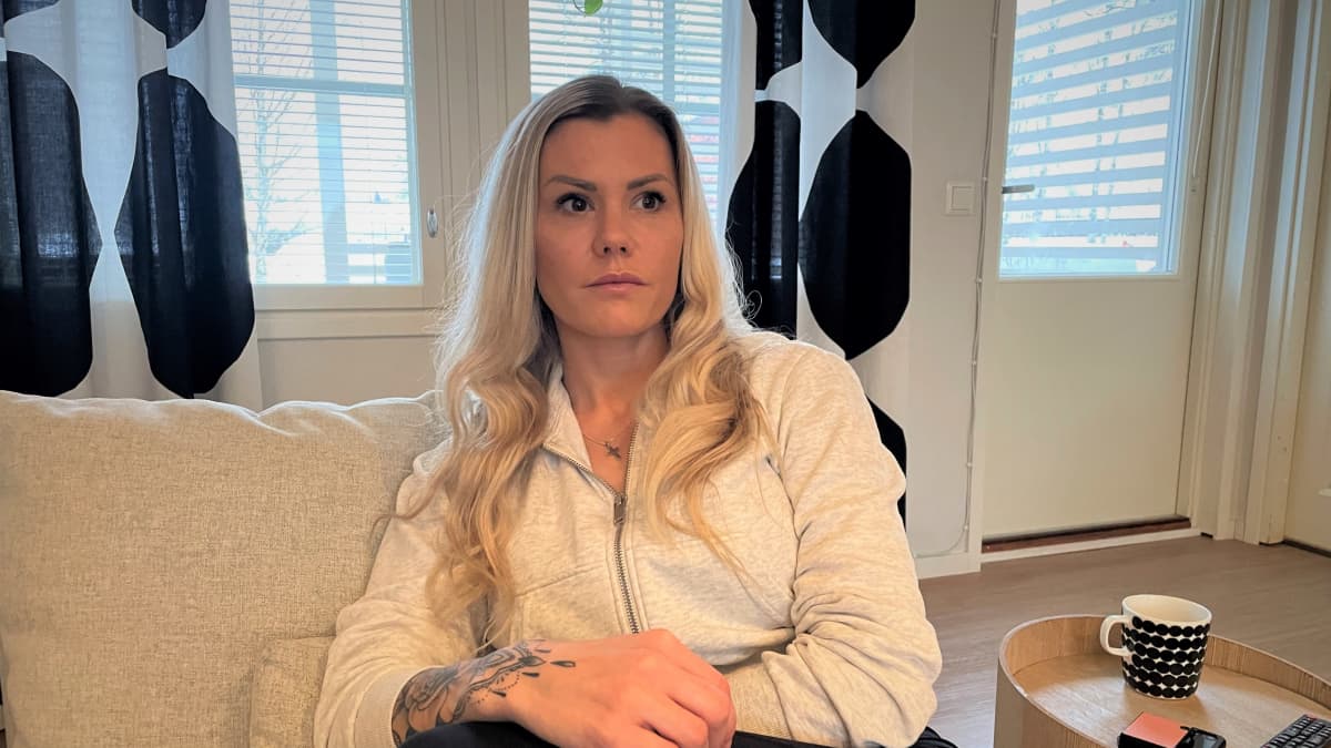 Lapualainen Marika Tuominiemi istuu sohvalla kotonaan.