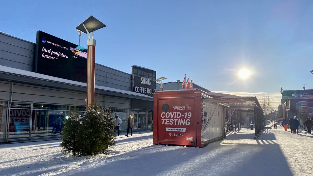 Punainen koronatestauskontti, aurinko paistaa taustalla. 