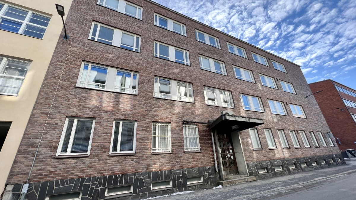 Ulkoa otetussa kuvassa näkyy tiilitalon ulkoseinää ja ovi.
