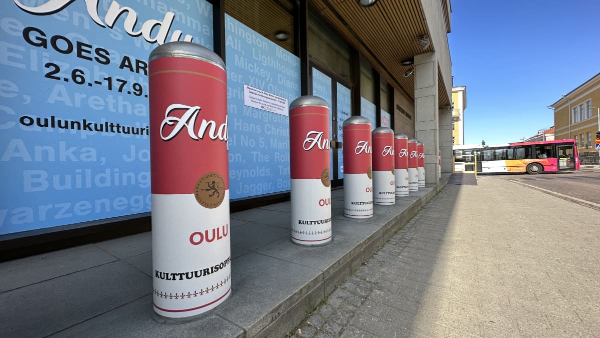 Oulun Kulttuuripankin julkisivu, jossa pilareita, jotka on päällystetty valkopunaisella kääreellä jossa mainostetaan Andy Warholin taidenäyttelyä. 
