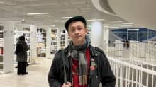 Opiskelija Vili Nurmi Helsingin yliopiston pääkirjastossa. Taustalla kirjaston hyllyjä.