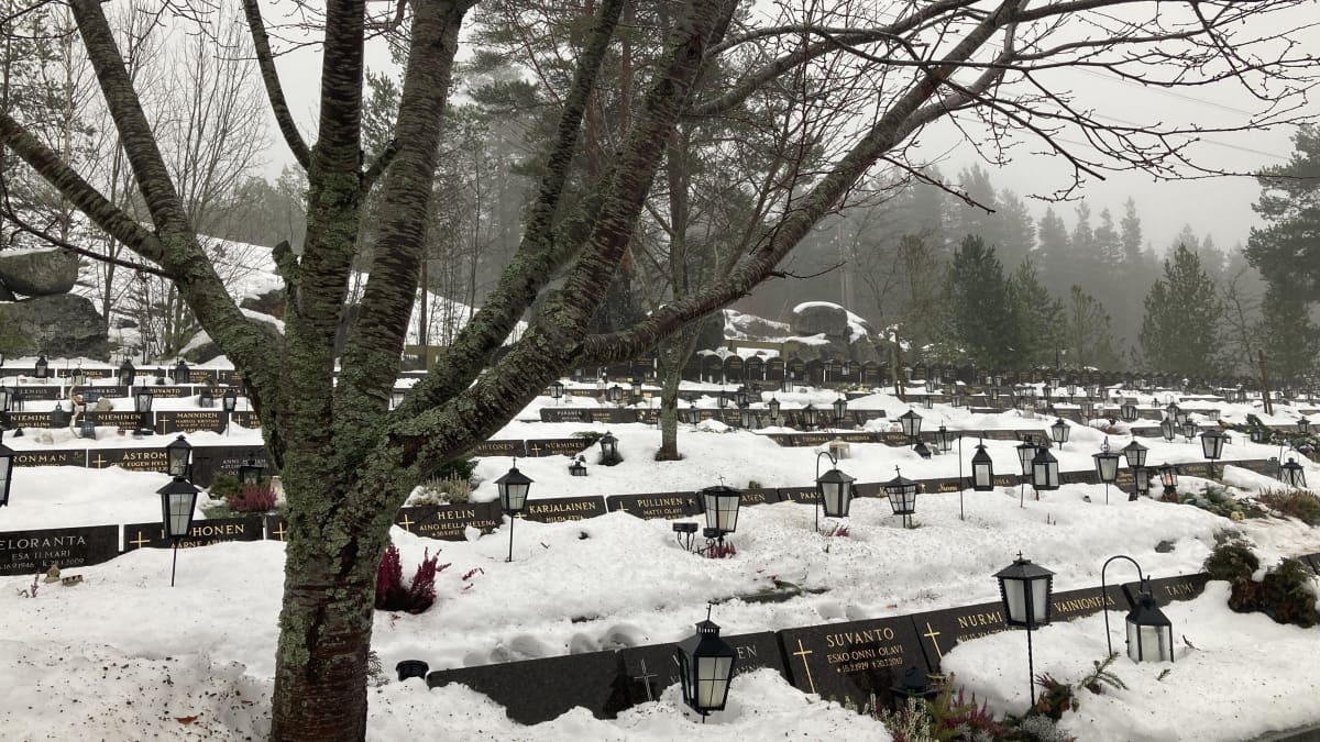 Hautausmaan uurna-alue, jossa runsaasti samankokoisia hautakiviä, jotka ovat osin lumen peitossa.