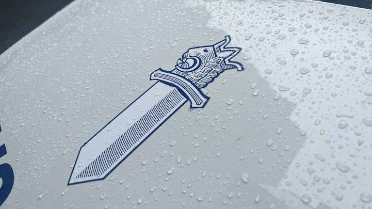 Poliisin miekkaleijonan kuva poliisiauton konepellissä.