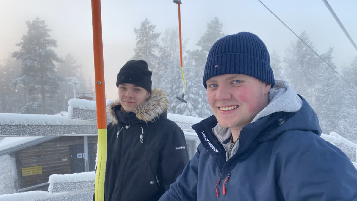 Topias (vasemmalla) ja Tino Piipponen ulkona Vuorenmaan rinnehiihtokeskuksen hiihtohissillä lumisessa maisemassa. 