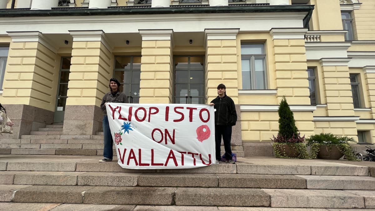 Opiskelijoita Helsingin yliopiston edustalla, pitävät lakanaa, jossa lukee "yliopisto on vallattu".