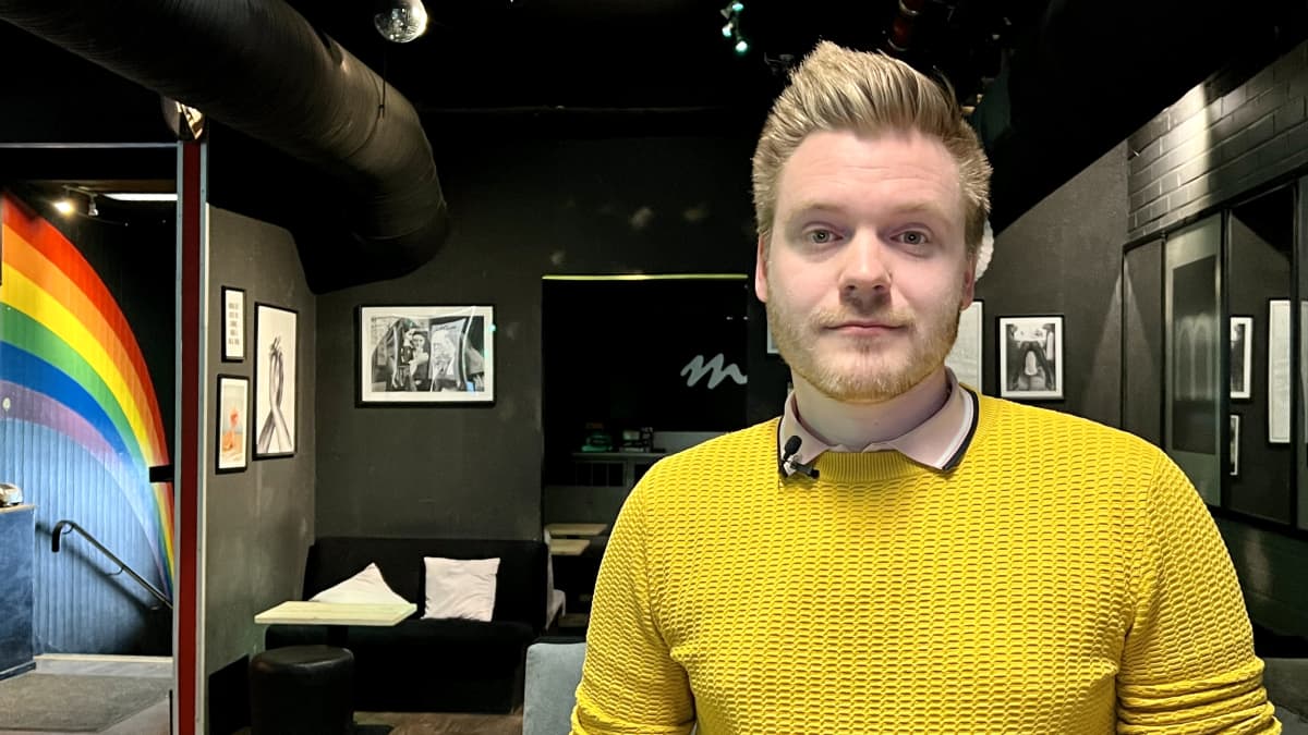 Väinö Kähkönen, wearing a yellow sweater, looking into the camera.