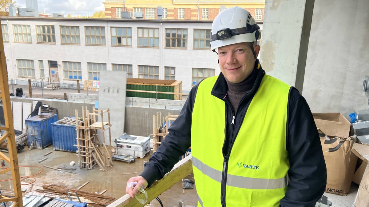 Tom Allen Seneran teknologiajohtaja Mika Manner nojaa tilapäiseen kaiteeseen keskeneräisen kerrostalon parvekkeella.