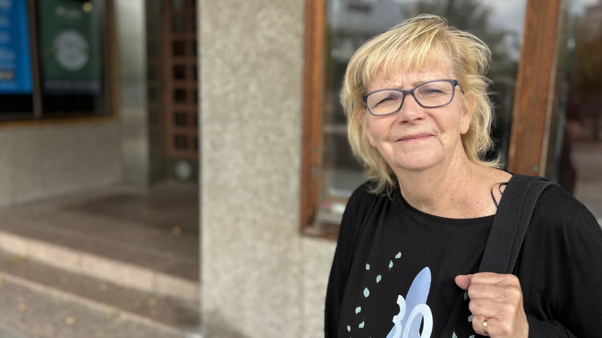 Silmälasipäinen nainen katsoo kameraan. Hänellä on yllään t-paita, jossa lukee Blue Sea Film Festival.