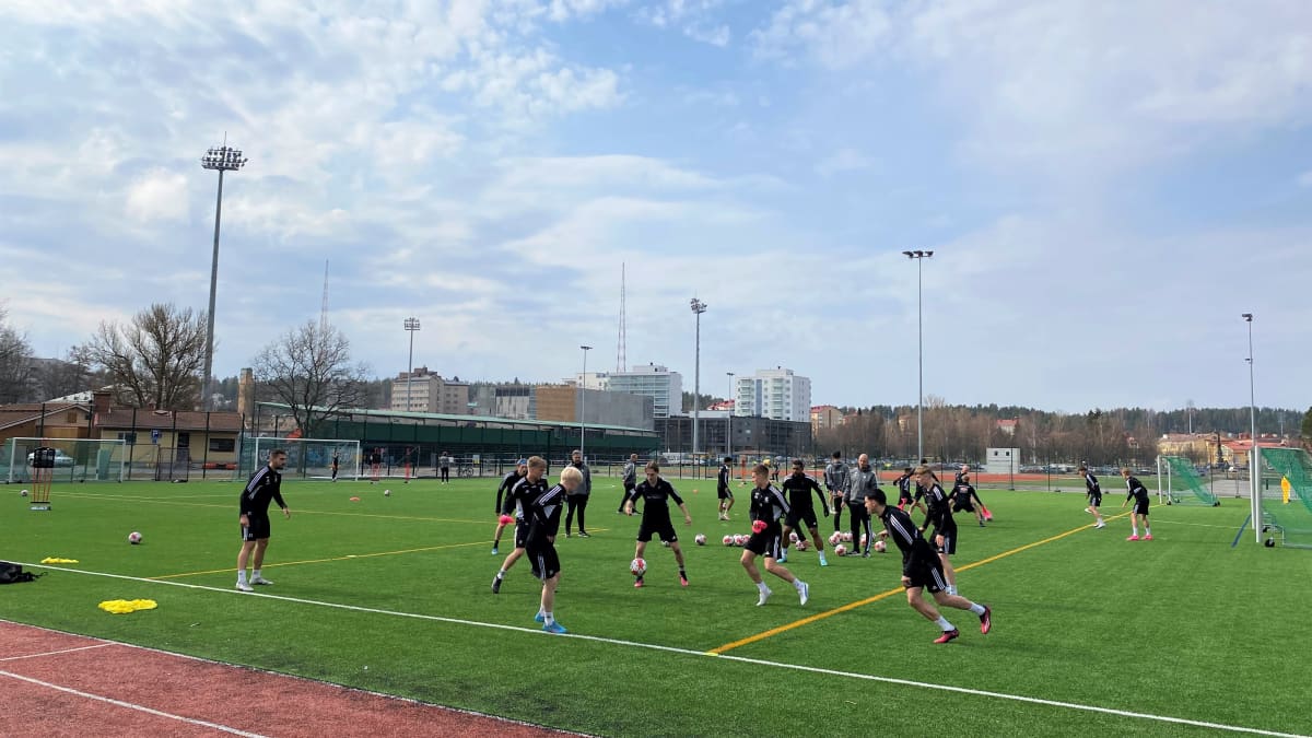FC Lahden jalkapalloilijat ovat harjoituksissa tekonurmikentällä. Pelaajat piirissä ja potkivat palloa.