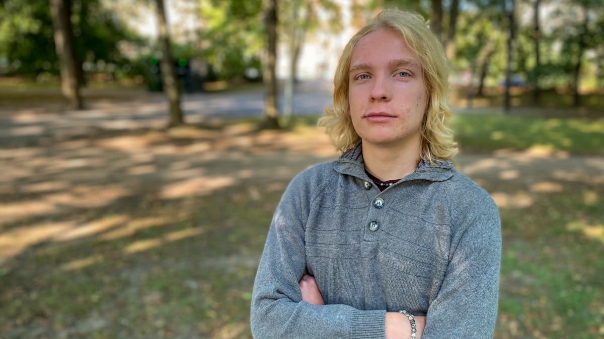 Elias Simojoki seisoo puistossa Töölönlahdella ja katsoo suoraan kameraan. 
