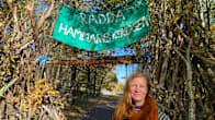 Sofia Olsson framför banderoll med texten rädda Hammarbyskogen