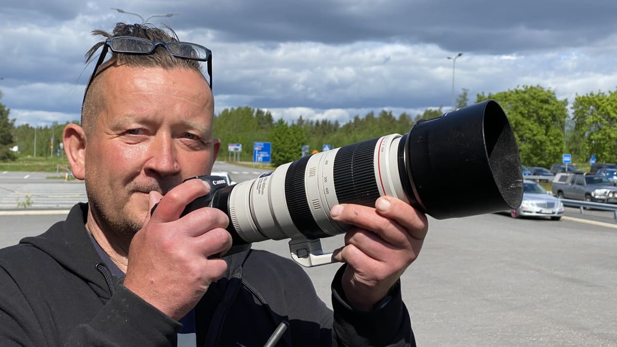 Kimmo Mäkiselkä pitää kädessään isolla putkella varustettua kameraansa.
