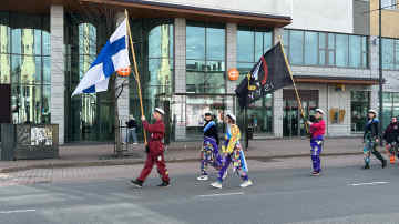 Haalareihin pukeutuneet opiskelijat kantavat Suomen lippua ja Itä-Suomen yliopiston ylioppilaskunnan lippua.