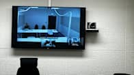 On the TV screen, a remote session of a district court.