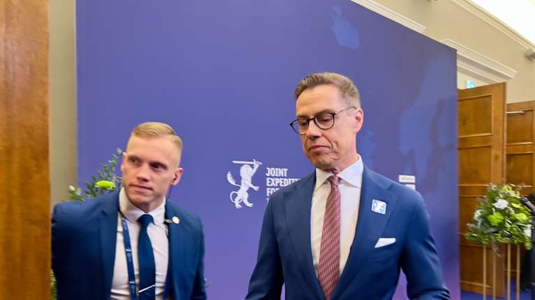 Pukuun ja solmioon pukeutunut presidentti Alexander Stubb poistumassa haastattelutilasta JEF-maiden kokouksessa Tallinnassa.
