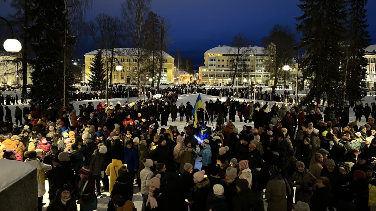 Iso joukko ihmisiä oli kerääntynyt Kuopion tuomiokirkon edustalle kuuntelemaan kynttiläkuoroa.