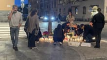 Nuoret asettelevat kukkia ja kynttilöitä paikalle, jossa 19-vuotias mies ammuttiin kuoliaaksi. 