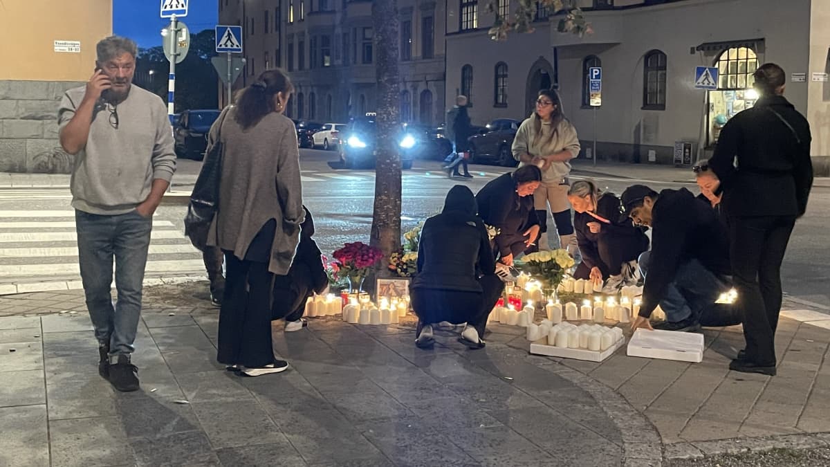 Nuoret asettelevat kukkia ja kynttilöitä paikalle, jossa 19-vuotias mies ammuttiin kuoliaaksi. 