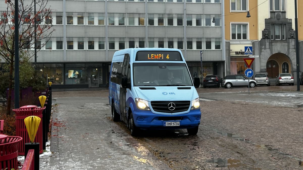 Sininen joukkoliikenteen pakettiauto ajaa loiskaisella tiellä Lahden keskustassa.