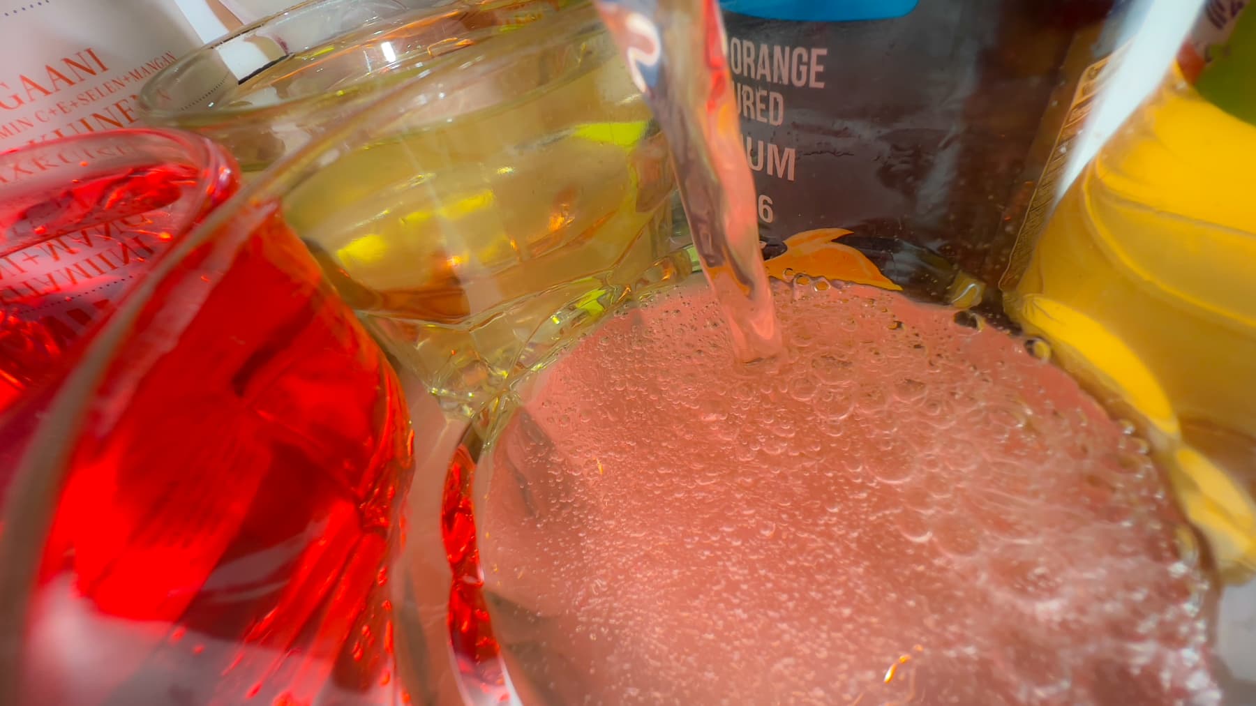 Persikan väristä vitamiinijuomaa kaadetaan lasiin.