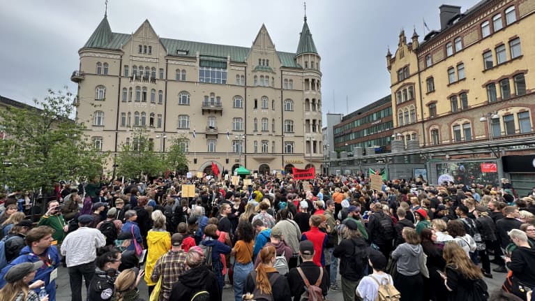 Ihmisiä seisoo porukassa Tampereen keskustassa sijaitsevalla torilla.