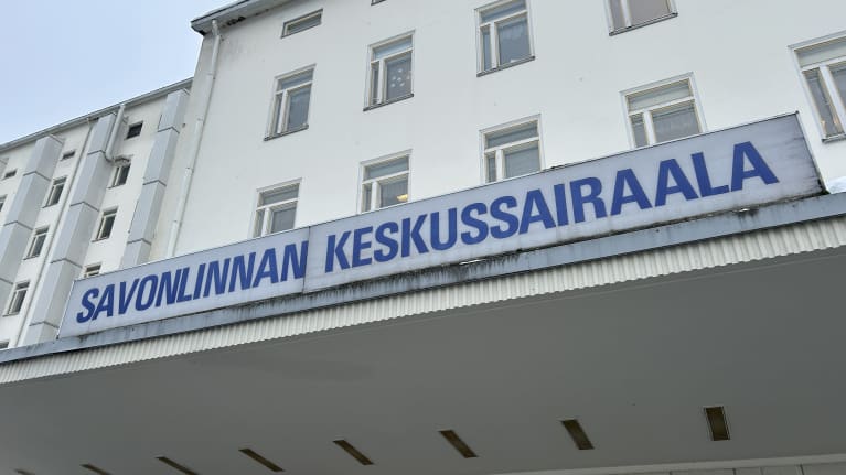 Rakennuksen katoksen yllä oleva vanha ja ränsistynyt kyltti, jossa lukee Savonlinnan keskussairaala.