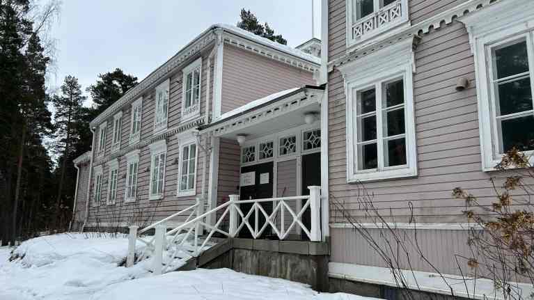 Puurakenteinen vaaleanpunainen Hotelli Punkaharju lumisessa maisemassa.