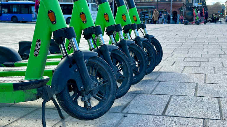Neljä vihreää sähköpotkulautaa rivissä Tampereen keskustassa. Kuvauspäivä 15.4.2024.