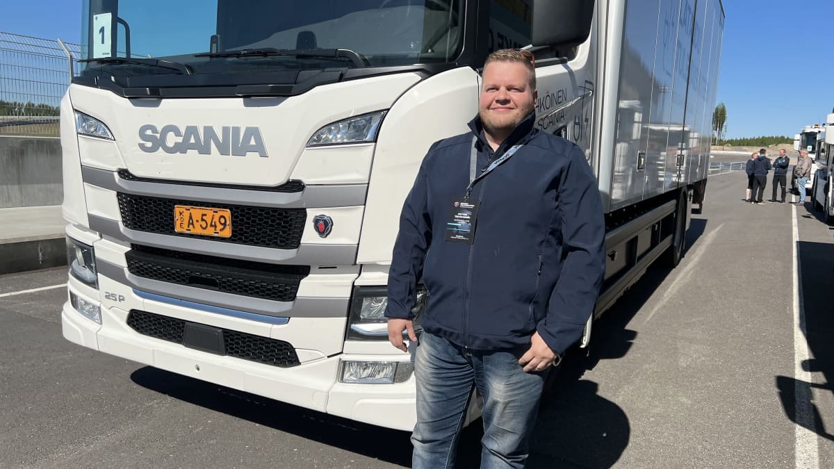 Valion kehityspäällikkö Petteri Tahvanainen seisoo Kymiringin varikkoalueella sähköisen Scania-kuorma-auton edessä.