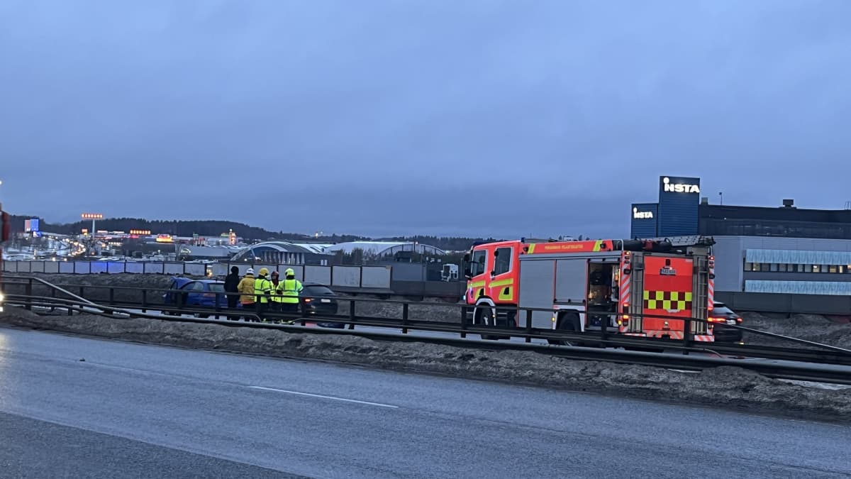 Paloauto ja pelastustyöntekijöitä keltaisissa liiveissä Tampereen läntisellä kehätiellä. Sinisen henkilöauton etupelti on vaurioitunut.