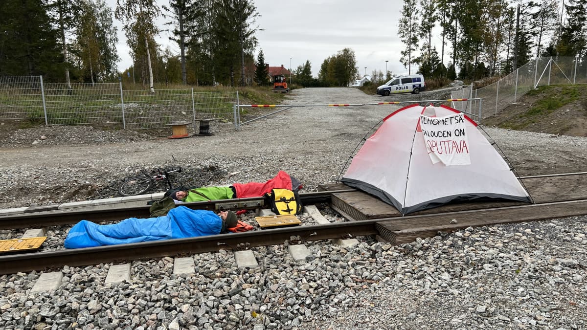 Elokapinan mielenosoittajat makaavat makuupussissa Metsä Groupin Kemin tehtaalle vievillä rautatienkiskoilla.