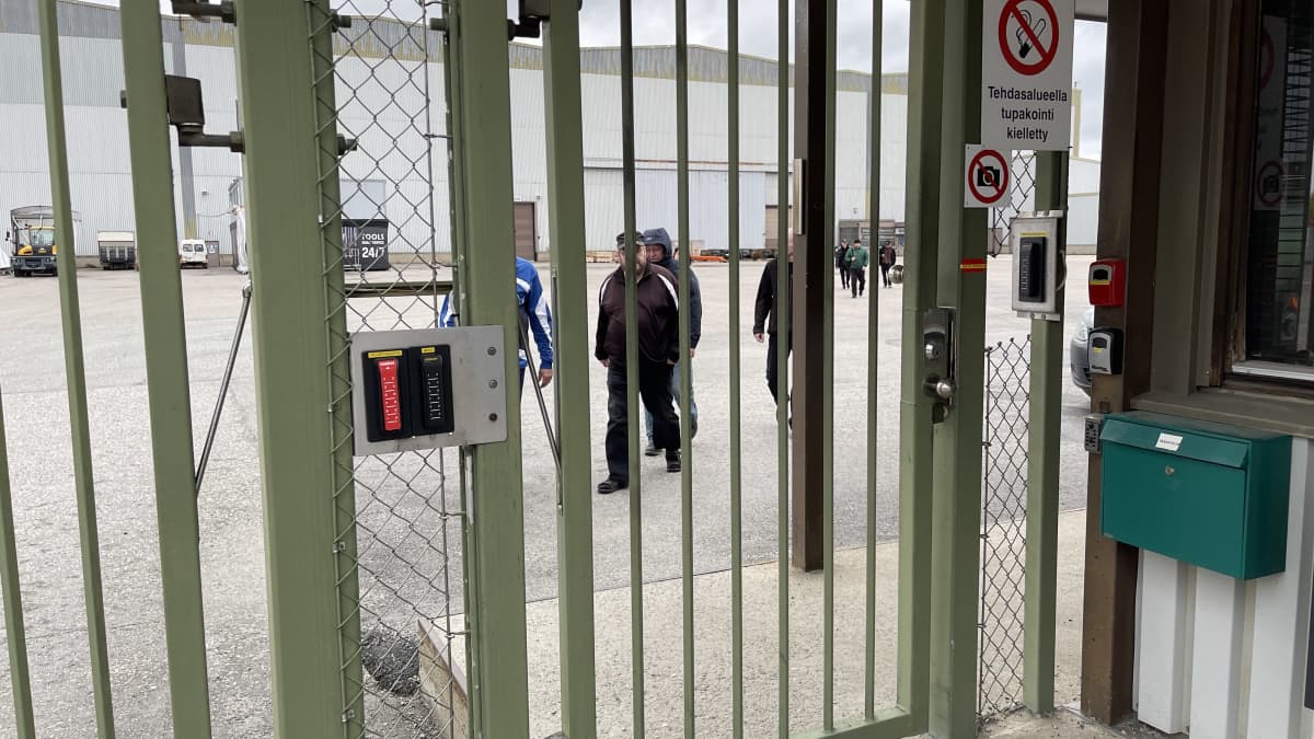 Škoda Transtechin työntekijöitä näkyy portin takana.