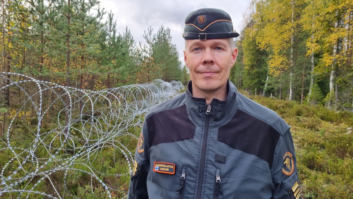 Jukka Lukkari kuvattuna maastossa piikkilankaesteen vieressä.