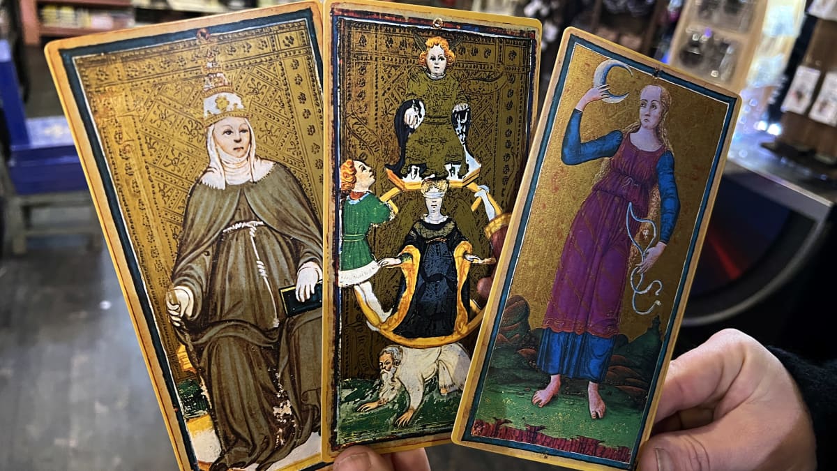 Käsinmaalatut, kultapohjaiset tarotkortit, joissa kuvattuna ylipapitar-, kohtalon pyörä - ja kuusymbolit.