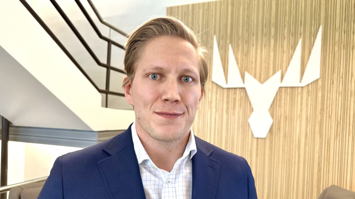  Suomen ja Baltian toimitusketjusta vastaava johtaja Joonas Kukkonen. Kukkosella on yllään tummansininen takki ja ruutukauluspaita. Taustalla Metsä Groupin logo puuseinällä. Kuvauspäivä 12.2.2024.