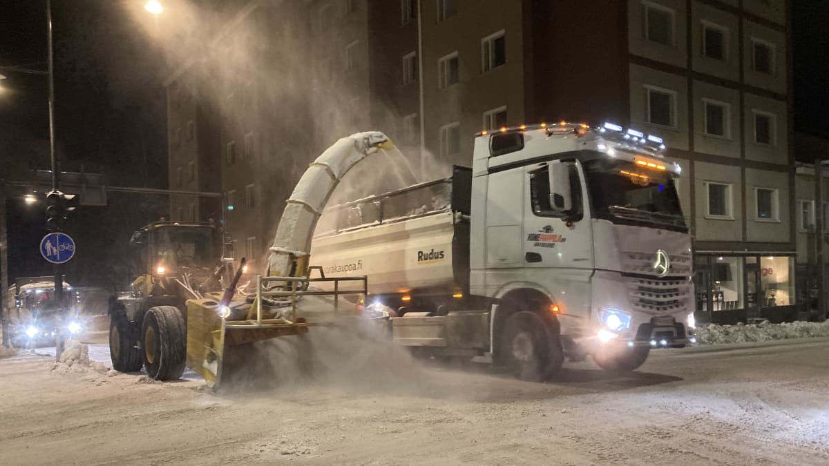 Lumenpoistoa Kuopion keskustassa. Lumi lingotaan kuorma-auton lavalle putkea pitkin.