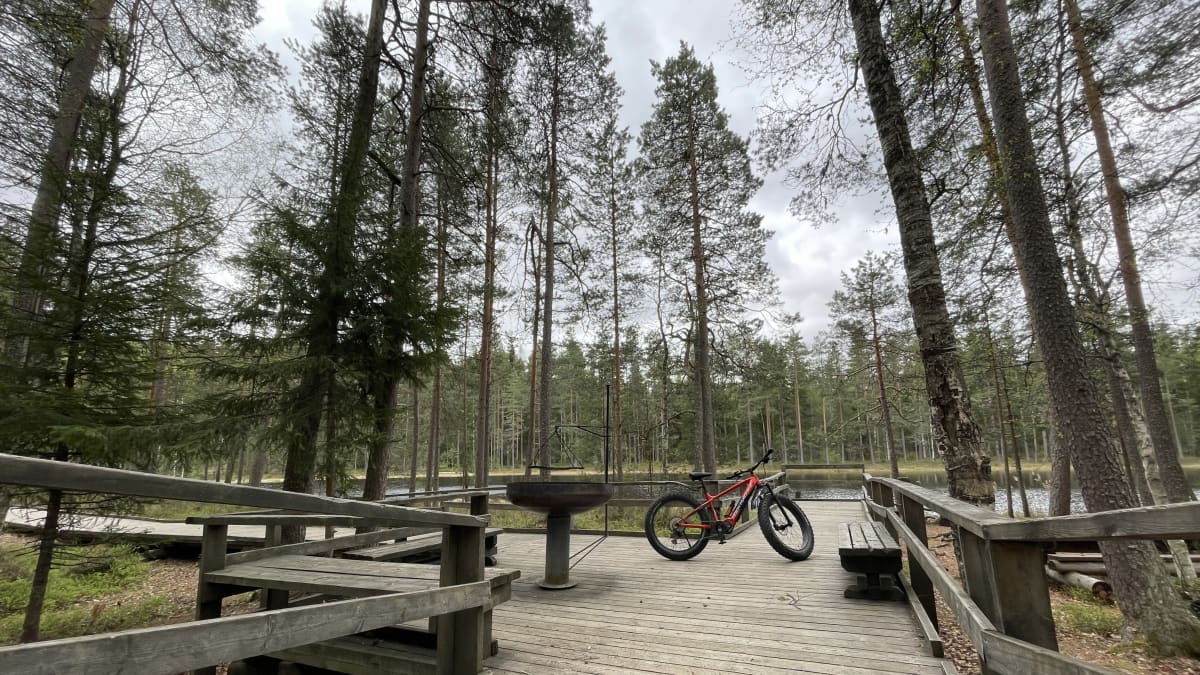 Sähköavusteinen maastopyörä luontopolun taukopaikalla.
