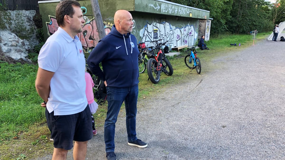Valmentajana toimiva Joni Yrjänheikki ja SPL:N läntisen alueen aluepäällikö Jouni Koivuniemi seuraavat ottelua Turussa Juhannuskukkulan kentällä.