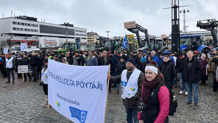 Yleisöä ja traktoreita Kuopion torilla. 