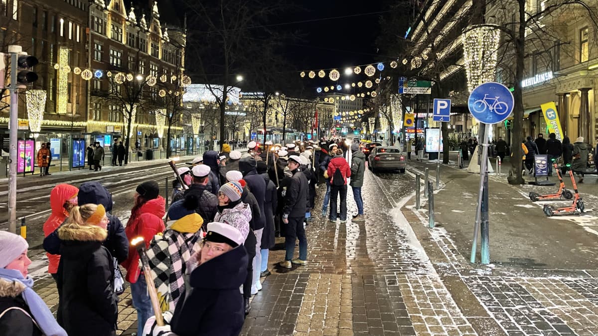 Människor på stan inne i Helsingfors centrum. De går i en parad.