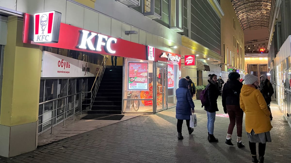 Ihmisiä kulkee kauppakeskuksen kadulla. KFC-pikaruokaketjun ravintola on kuvassa vasemmalla. Sen takana näkyy Pizza Hutin ravintola.