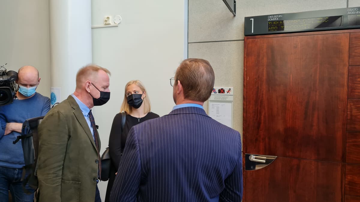 vastaaja selin kameraan oikeustalolla