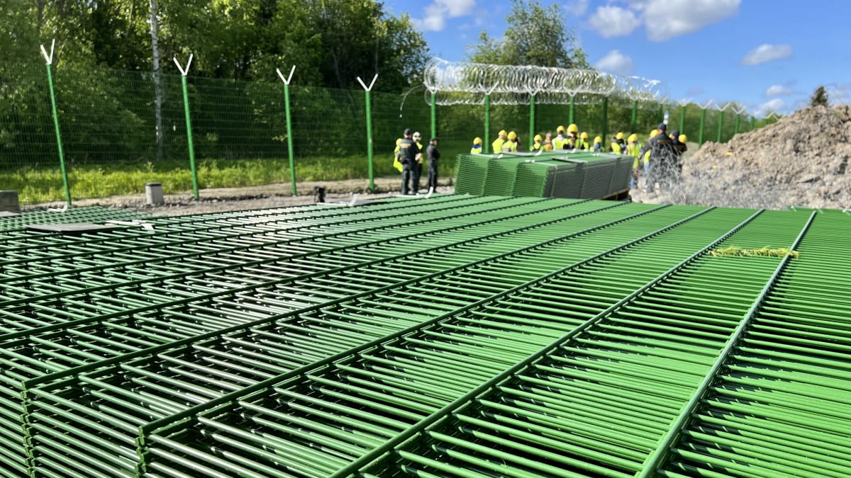 Photo shows a stack of fence railings waiting to be put in place.
